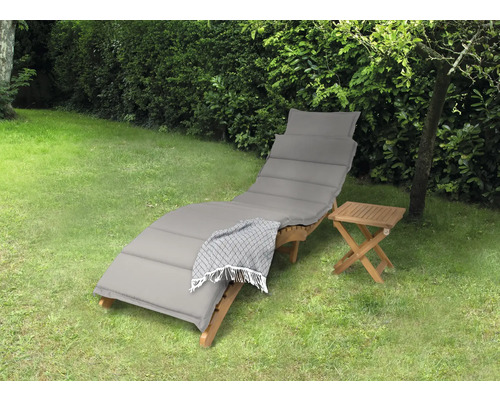 Gartenszene mit einer Holzliege, einer Auflage und einem Beistelltisch