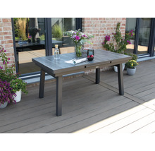 Ausziehbarer Gartentisch auf einer Terrasse mit Blumen und Dekorationen.