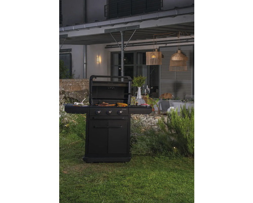 Schwarzer Grill auf einer Terrasse mit Grillgut