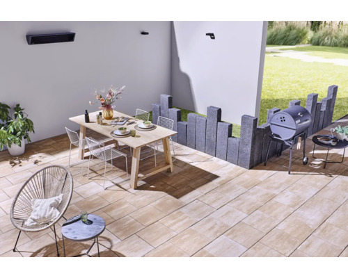 Espace extérieur aménagé avec table à manger, espace barbecue et coin salon sur des dalles de terrasse