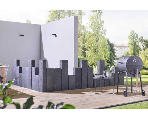 Espace extérieur avec barbecue, piliers en pierre et mobilier de jardin sur une terrasse