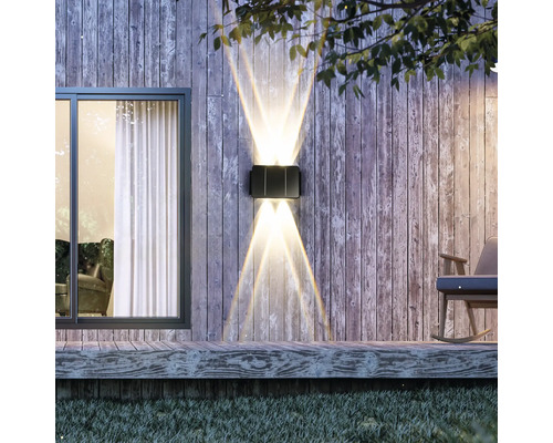 Applique murale extérieure illuminée sur un mur en bois à côté d''une fenêtre et d''un fauteuil à bascule.