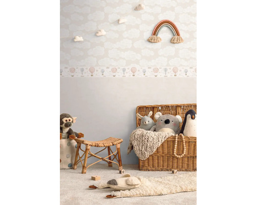 Chambre d''enfant avec papier peint nuages, jouets et panier en osier