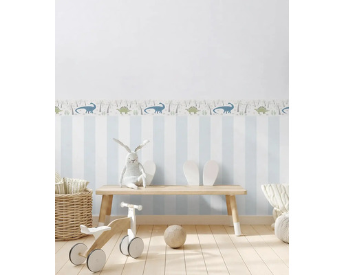 Chambre d''enfant avec papier peint à rayures, bordure de dinosaures, banc en bois et jouets