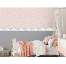Chambre d''enfant avec lit, table de chevet et papier peint rose avec motifs blancs