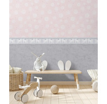 Chambre d''enfant avec papier peint à motifs, jouets et meubles en bois pour une ambiance lumineuse et conviviale.