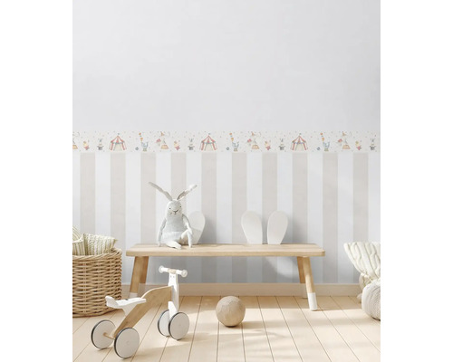 Chambre d''enfant avec papier peint rayé, bordure de cirque, bancs en bois, draisienne, peluche et ballon