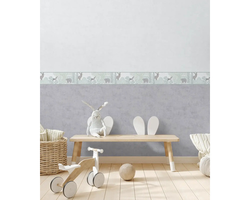 Chambre d''enfant avec bordure de papier peint avec des illustrations d''animaux, plancher en bois et jouets.