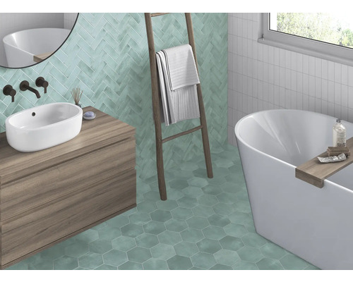 Salle de bains avec lavabo, baignoire, échelle et carreaux muraux et de sol de différentes formes