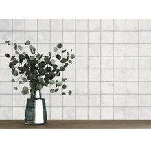 Mur avec des carreaux carrés et un vase avec de l''eucalyptus sur une table en bois