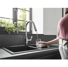 Robinet d''évier avec bec pivotant remplissant un verre d''eau dans une cuisine moderne.