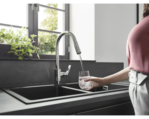 Robinet d''évier avec bec pivotant remplissant un verre d''eau dans une cuisine moderne.