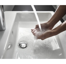Lavage des mains dans un lavabo en céramique blanche avec robinet