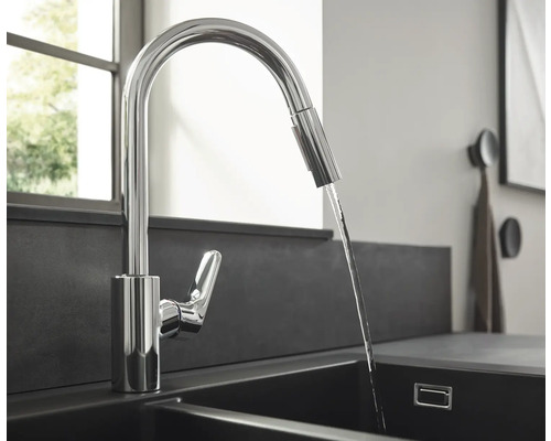 Robinet de cuisine en métal avec écoulement d''eau dans un évier