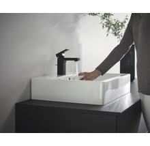 Une personne remplit un verre d''eau à un lavabo avec un robinet