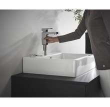Installation d''un robinet sur un lavabo blanc dans la salle de bain.