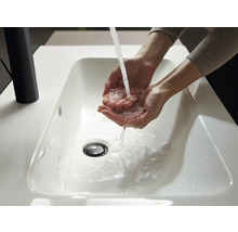 Les mains sont lavées dans un lavabo blanc avec de l''eau