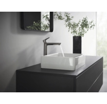 Waschtisch mit Aufsatzwaschbecken, Armatur und Spiegel in einem Badezimmer