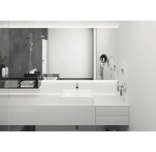 Salle de bains lumineuse avec lavabo, miroir, serviettes et douche