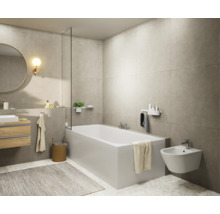 Salle de bain lumineuse avec baignoire, bidet, miroir et lavabo.