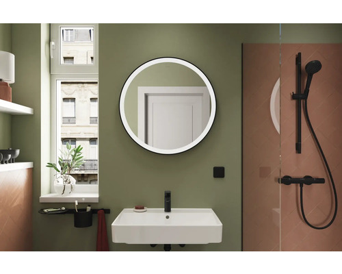 Badezimmer mit Waschbecken, rundem Spiegel und Dusche