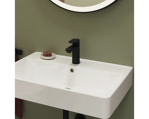 Weisses Waschbecken mit schwarzer Armatur und Seife