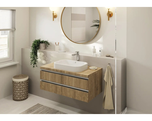 Badezimmer mit Waschtischunterschrank, Aufsatzwaschbecken, rundem Spiegel und Dekoration
