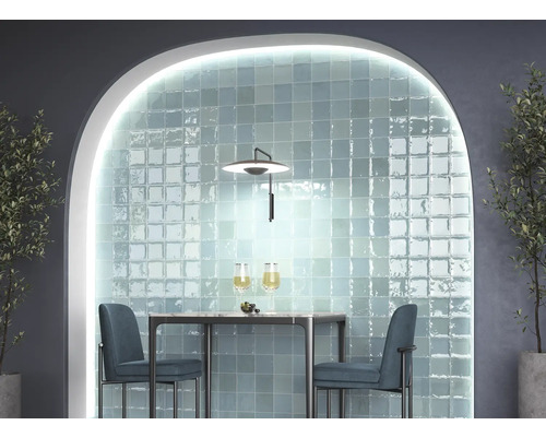 Salle à manger avec mur carrelé, table et chaises