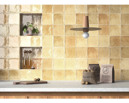 Mur de cuisine carrelé avec des carreaux carrés, des étagères, des décorations et des aliments