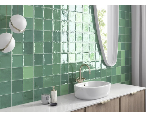Salle de bain avec carreaux verts, lavabo et miroir