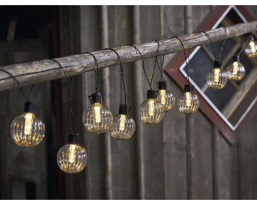 Guirlande lumineuse décorative avec des lampes rondes et claires fixées sur une branche