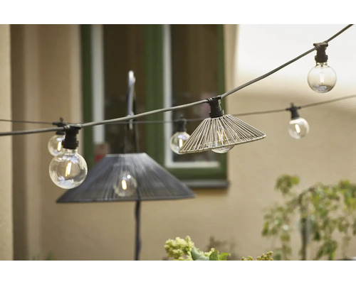 Dekorative Lichterkette mit Lampenschirmen und klaren Glühbirnen im Außenbereich