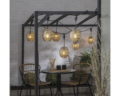 Gartenszene mit Lichterkette, Tisch und Stühlen für gemütliche Atmosphäre