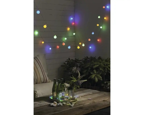 Dekorierte Terrasse mit Lichterkette, Getränken und Pflanzen für eine gemütliche Atmosphäre