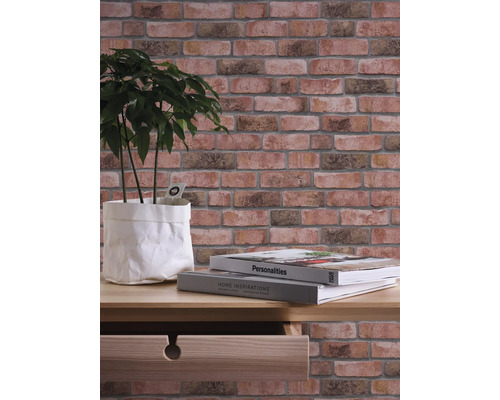 Décoration murale avec papier peint aspect pierre, plante et livres sur une table