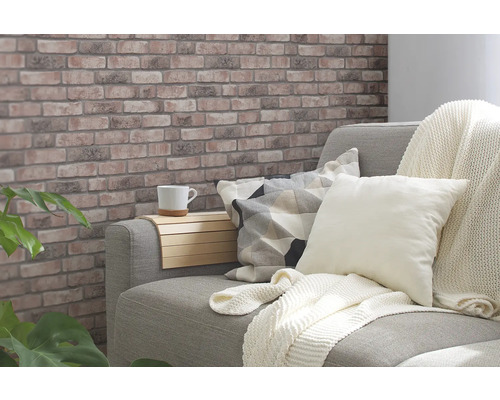 Salon confortable avec papier peint à motif de briques, canapé, coussins et table d''appoint