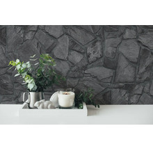 Mur en pierre décoratif avec plantes, bougie et objets décoratifs sur un plateau