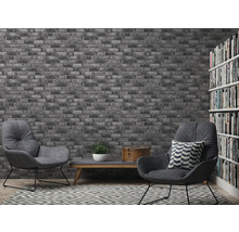 Salon avec papier peint en briques, fauteuils et bibliothèque pour une ambiance conviviale.