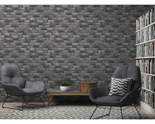 Salon avec papier peint en briques, fauteuils et bibliothèque pour une ambiance conviviale.