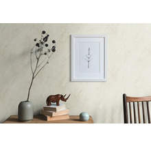 Scène décorative avec un cadre photo, un vase avec des fleurs séchées, une figurine de rhinocéros et des livres sur une table