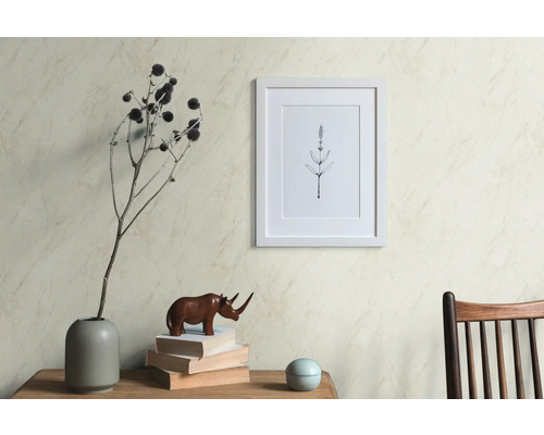 Scène décorative avec un cadre photo, un vase avec des fleurs séchées, une figurine de rhinocéros et des livres sur une table