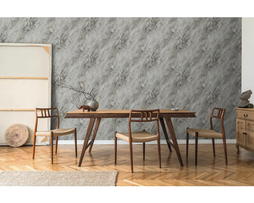 Salle à manger avec table en bois, chaises et papier peint gris à effet pierre.