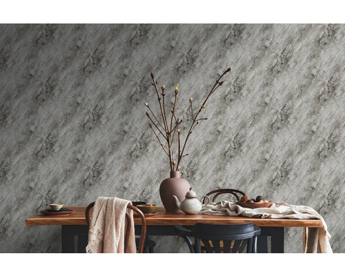 Table à manger avec vaisselle, décoration et papier peint à motif de marbre pour une ambiance claire et organisée.