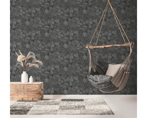 Salon avec papier peint motif pierre, fauteuil suspendu, coffre et tapis