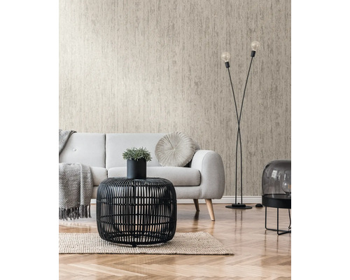Salon avec papier peint structuré beige, canapé et table en rotin noir