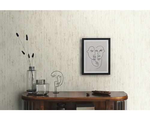 Intérieur avec papier peint à motifs, commode et objets décoratifs.