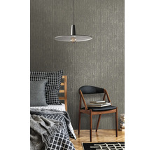 Scène avec un lit, une chaise, une lampe et un papier peint texturé