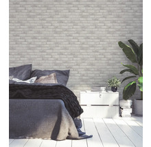 Chambre avec papier peint en briques, lit et plantes