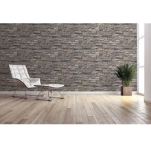 Pièce lumineuse avec papier peint imitation mur de pierre, fauteuil, tabouret et plante