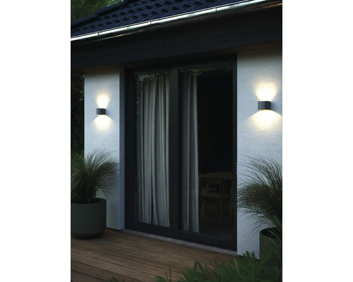 Extérieur d''une maison avec une porte de patio et deux appliques murales rondes de chaque côté.